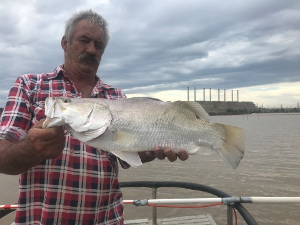 Fisherman holding a large Barramundi