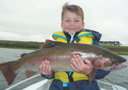 Young boy holding a large rainbow trout
