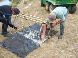 Two men assemble a fishing contraption