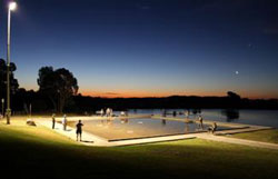 A photo of people fishing at night under lights