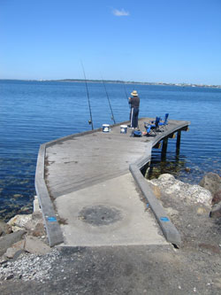 A man fishing at the fishing platform.